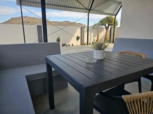 a black table and chairs with a view of the desert at Rosa's Self-catering in Springbok