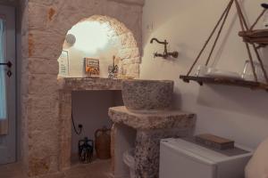 a bathroom with a stone fireplace and a sink at Trulli diffusi de La Corte dell'Astore I Trulli Antichi Mestieri in Alberobello +243 photos