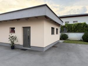 a white house with a garage at Apartma Tomy in Domžale