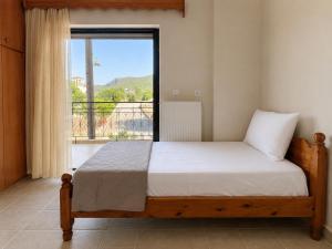 a bedroom with a bed and a large window at Dimitris house in Parga