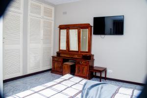 a bedroom with a dresser and a mirror and a bed at Hotel Redcliff in Redcliff
