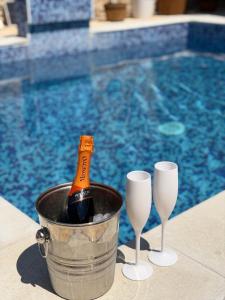 a bottle of champagne in a bucket next to two wine glasses at App 2 Ville Adan in Zemuniki