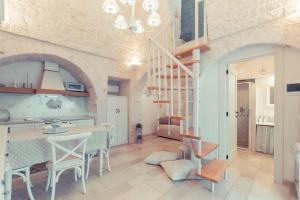 a kitchen and dining room with a table and a staircase at Trulli diffusi de La Corte dell'Astore I Trulli Antichi Mestieri in Alberobello
