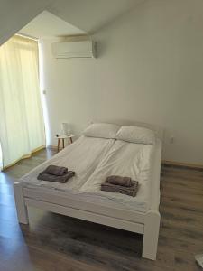 a white bed in a room with two towels on it at Montenegro Summer time in Igalo