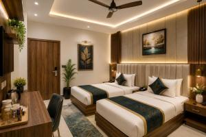 a hotel room with two beds and a desk at Hotel The RTS Plaza in New Delhi
