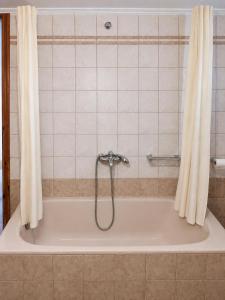 a bath tub with a shower in a bathroom at Dimitris house in Parga +9 photos