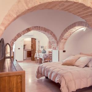 a bedroom with a large bed with an archway at Trulli diffusi de La Corte dell'Astore I Trulli Antichi Mestieri in Alberobello
