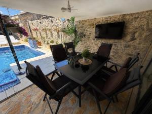 a dining room with a table and chairs and a pool at App 2 Ville Adan in Zemuniki
