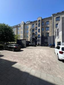 a parking lot with cars parked in front of a building at Prinsen Hotel in Aalborg