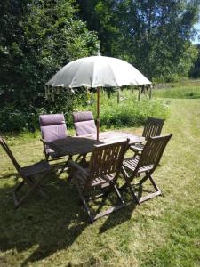 a picnic table with two chairs and an umbrella at Ruissalo Cottage in Turku