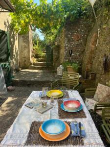 a table with plates and wine glasses on it at Casina Orione in Montecatini Val di Cecina