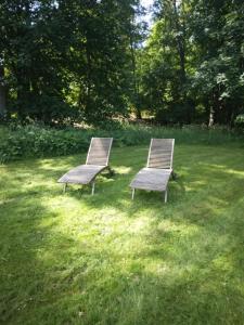 two benches sitting in the grass in a field at Ruissalo Cottage in Turku