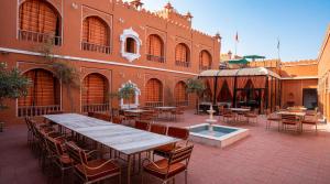 a patio with tables and chairs and a building at Garrison at Dera Bagseu in Bikaner