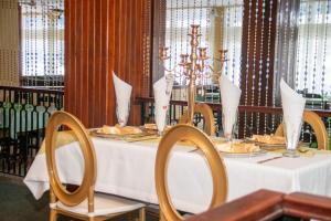 a table in a restaurant with a white table cloth and chairs at Hotel Redcliff in Redcliff
