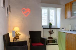 a kitchen with two chairs and a heart on the wall at Rustico senza punti in Contra +11 photos