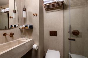 a bathroom with a shower and a toilet and a sink at Enavlion Elegance Seaside Luxury in Chrysi Ammoudia +42 photos