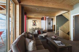 a living room with a couch and a table at L'Aiguille Grive Chalets Hotel in Arc 1800