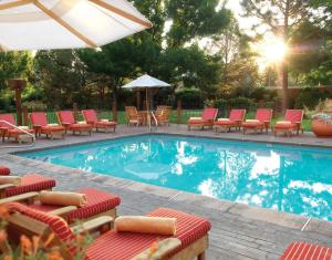 a pool with chairs and umbrellas in it at Inn & Spa at Loretto in Santa Fe
