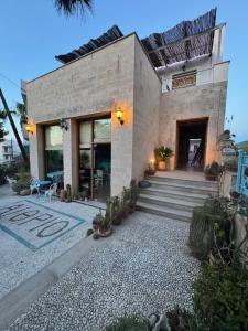 a brick house with a staircase in front of it at Aethrio Guesthouse in Souvala