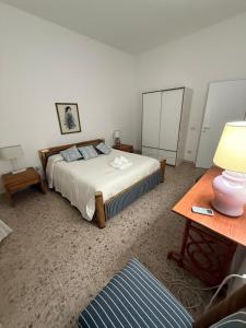 a bedroom with a bed and a table with a lamp at Orange Home in Olbia