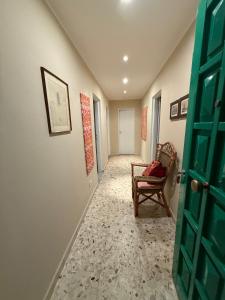 a hallway with a door and a chair in a room at Orange Home in Olbia