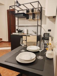 a table with two plates and wine glasses on it at Casa Vacanze Del Pescatore in Passignano sul Trasimeno