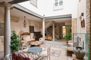 a living room with a table and chairs at Apartamentos Luna Suites Palacio Almagra in Granada