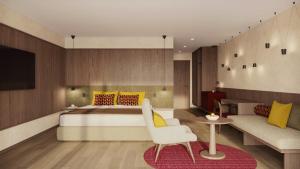 a bedroom with a bed and a chair and a couch at Ganis Resort in Nova Ponente