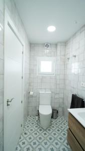 a white bathroom with a toilet and a sink at Casa Las Conchas in La Rábita +28 photos