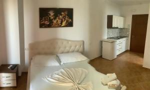 a bedroom with a bed and a painting on the wall at Erjani Hotel in Velipojë