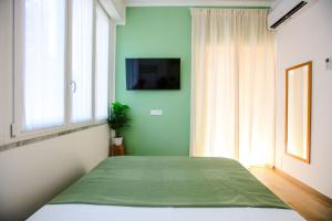 a green bedroom with a bed and a window at Pole Pole - NATURA in Agropoli