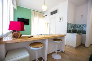 a room with a desk with a red lamp and stools at Pole Pole - NATURA in Agropoli +6 photos