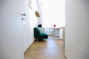 a hallway with a green chair in a white room at Pole Pole - NATURA in Agropoli