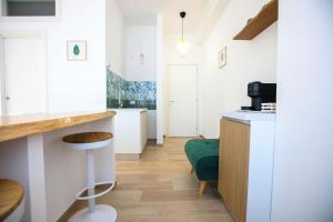 a kitchen with white cabinets and a green chair at Pole Pole - NATURA in Agropoli