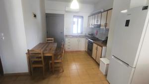 a kitchen with a wooden table and a refrigerator at Erofili in Pefkochori