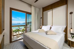 a bedroom with a bed and a view of the ocean at Enavlion Elegance Seaside Luxury in Chrysi Ammoudia