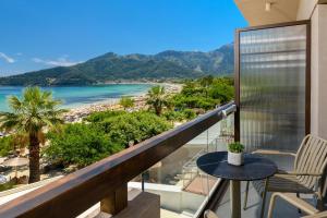 a balcony with a table and chairs and a view of the beach at Enavlion Elegance Seaside Luxury in Chrysi Ammoudia