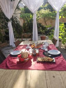 a table with food on a red table cloth at chambres d'hôtes l'atrium in Orange +23 photos