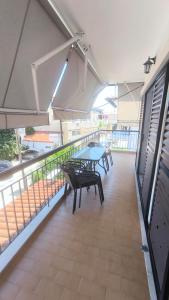a patio with a table and benches on a balcony at Erofili in Pefkochori