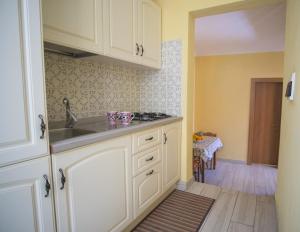 a kitchen with white cabinets and a sink at luxury B&B SUITE JACUZZI VILLA FILOMENA in Marina di Camerota +78 photos
