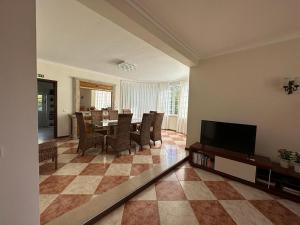 a living room with a table and chairs and a television at Casa Loureiro - Vista Rio Douro in Resende