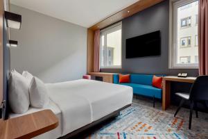 a hotel room with a bed and a couch at Aloft by Marriott Munich in Munich