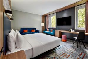 a hotel room with a large bed and a desk at Aloft by Marriott Munich in Munich +50 photos