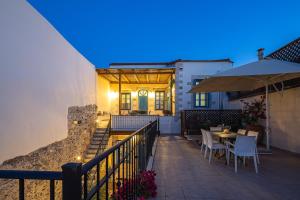 a patio with a table and chairs and an umbrella at Villa Aposperitis in Panormos Rethymno