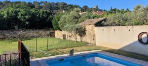 a swimming pool in a yard next to a fence at Gîte la Cabridello in Barbentane