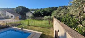 a backyard with a swimming pool and a fence at Gîte la Cabridello in Barbentane