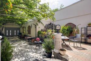an outdoor patio with tables and chairs and plants at Hotel Livin in Tbilisi City