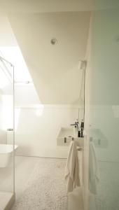 a white bathroom with a sink and a mirror at Old Town Apartment with FREE Parking in Marijampolė