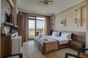 a hotel room with a bed and a large window at Hotel Livin in Tbilisi City +61 photos