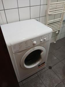 a white washing machine in a room with a tile wall at апартамент Хармония in Gotse Delchev